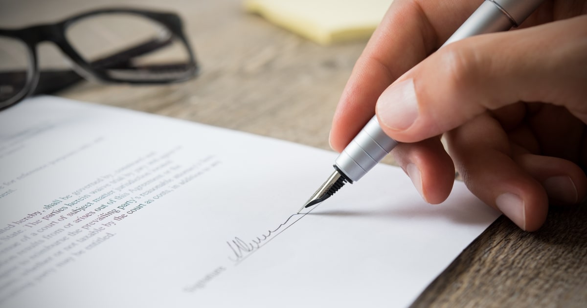 What to consider when preparing a will, close up of signing.
